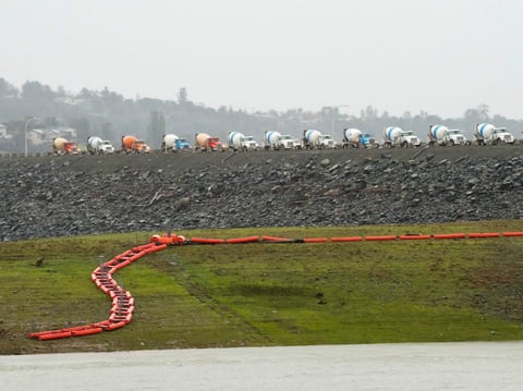A long line of concrete trucks wait on the top of Oroville Dam to deliver concrete for the erosion repair work at the base of the Oroville Dam emergency spillway on February 17, 2017.